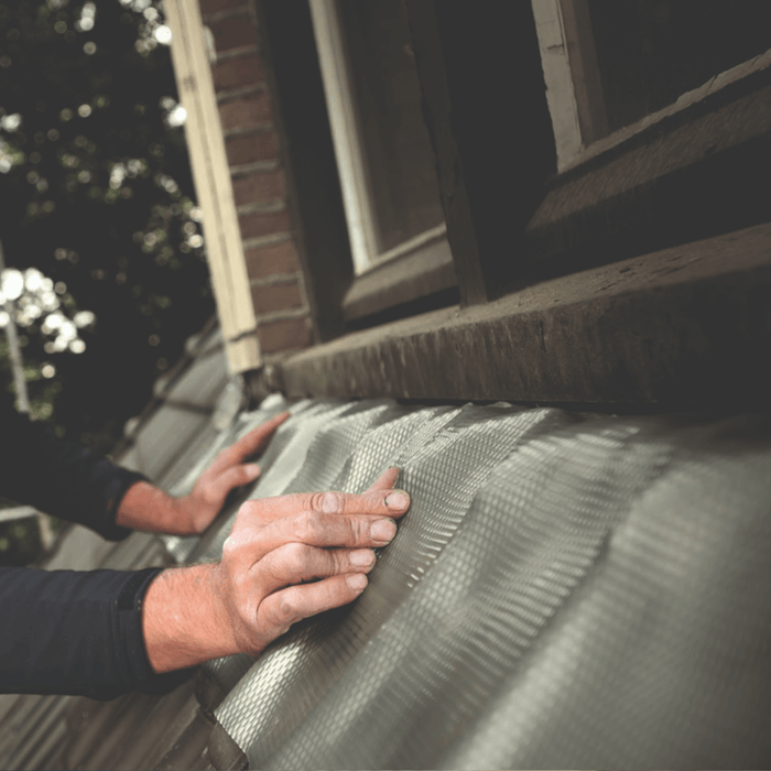 An image of Leadax being fitted as flashing on the side of a house using Sealant.