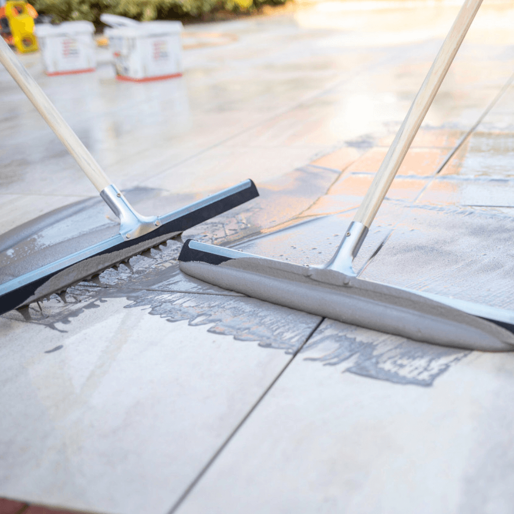 An image of Azpects Slurry Grout being pushed into gaps in paving as a jointing compound