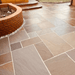 An image of Autumn Brown Indian Sandstone Paving laid out to show how it looks when wet