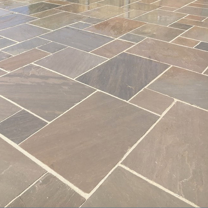 An image of Autumn Brown Indian Sandstone Paving laid out to show how it looks when wet.