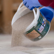An image showing Azpects EASY Patio Joint Repair in the colour Grey Beige being poured out onto gaps in paving ready to use