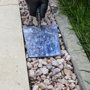An image showing chippings / gravel / aggregates being pushed down and into place after having Azpects EASYScape Gravel Hold being applied before it dries. 