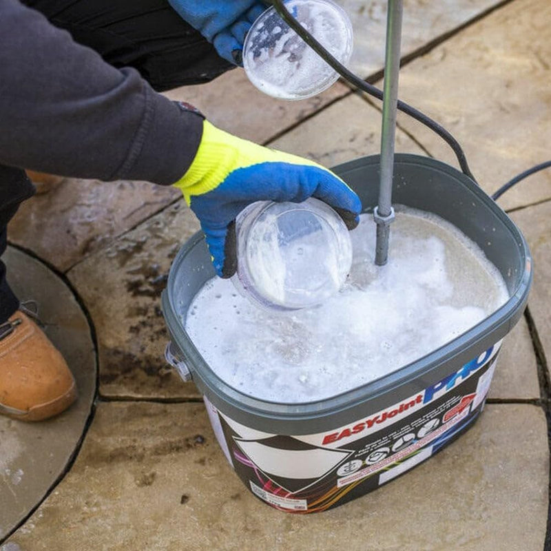 An image of the activating ingredients being poured into a tub of Azpects easyjoint PRO heavy duty paving jointing compound.