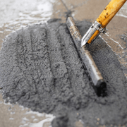 An image of a 12.5kg tub of EasyJoint Select Paving Compound being pushed into gaps in paving slabs with a Squeegee
