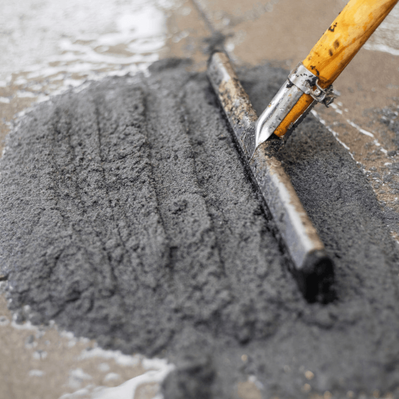An image of a 12.5kg tub of EasyJoint Select Paving Compound being pushed into gaps in paving slabs with a Squeegee