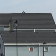 An image of two houses with grey Britmet roof tiles that have Cover flashing strips.