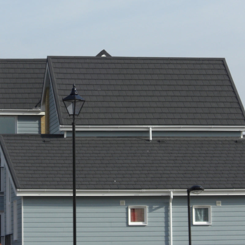 An image of two houses with grey Britmet roof tiles that have Cover flashing strips.
