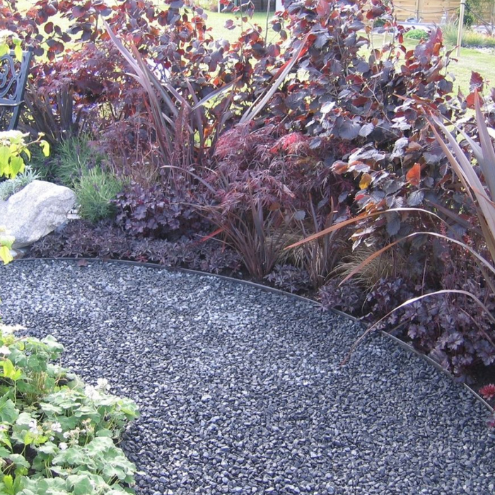 An image of black basalt aggregate stones on a garden path to show the finish it gives.