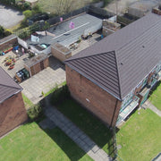 An image of a house with Britmet Pantile 2000 Roof tiles and Hip End Caps in the colour Mid Grey