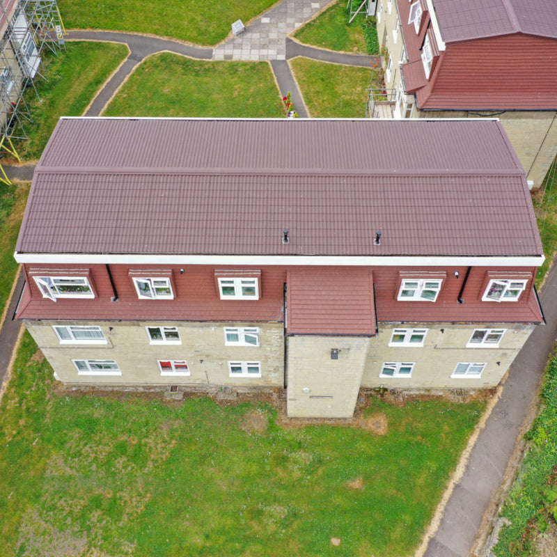 An image showing the roof of a house fitted with Britmet Pantile 2000 Roof Shingle Sheets in the colour Terracotta