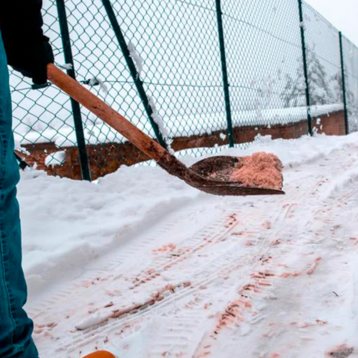 Image of Brown rock salt being used on an path to de-ice it and clear the snow.