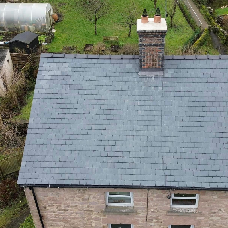 Roof of a house with a chimney stack with Chinese slates