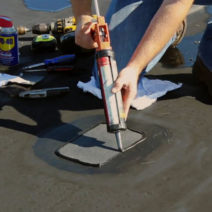 An image of ClassicBond Sure-Seal EDPM Carlisle Lap Sealant Adhesive being applied to a patch on a roof.