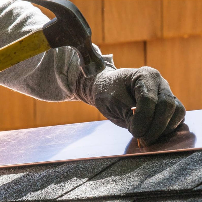 An image of a copper clout nail a larger head than normal nails being used to secure copper flashing.