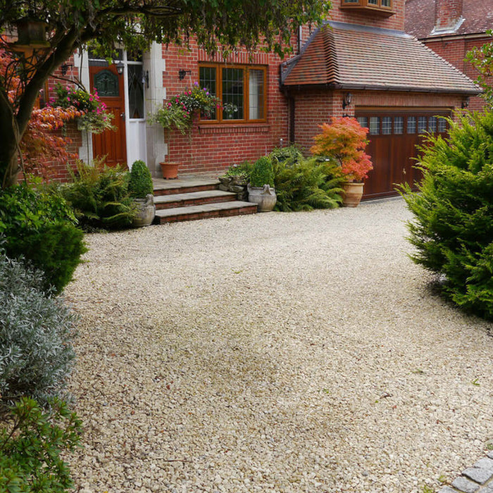 An image of Cotswold Buff Stone Chippings laid out on a drive