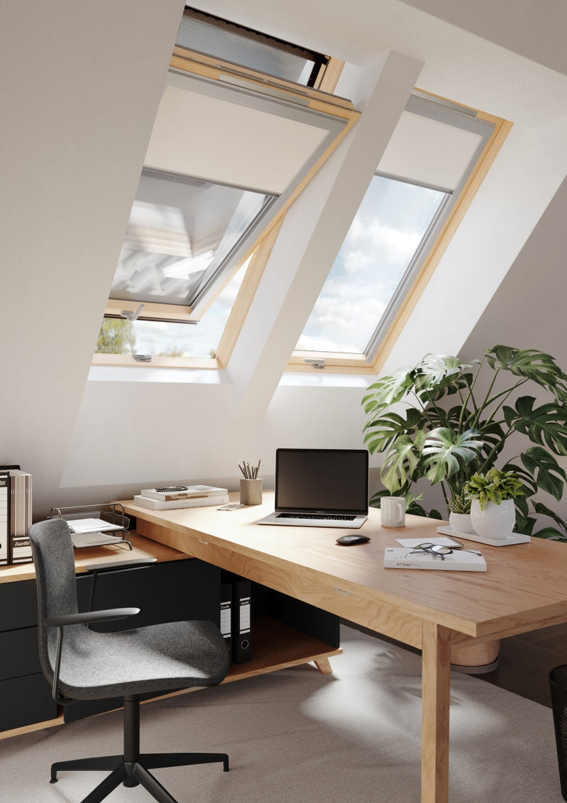 An image of a Dakea Better Energy Centre Pivot Roof Window with a Pine finish KAV B1500 installed above an office space to show how they look.