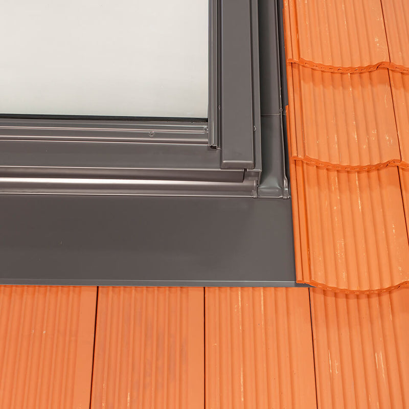 An image showing a close up of a Dakea Tile Flashing For Interlocking Flat Tiles KFT. It is an image from the outside of a roof to show what they look like when installed.