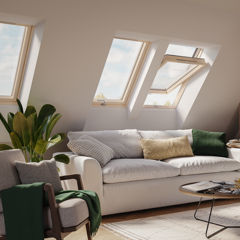 An image showing a Dakea Ultima Comfort Centre Pivot Roof Window with a wooden frame in a living room