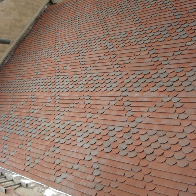 An image showing a roof of Dreadnought Clay Tiles with Bullnose details, they are Smooth Red / Blue Blend in colour