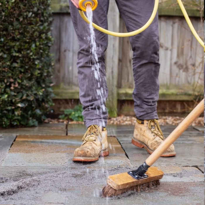 An image of easy joint paving jointing compound being brushed into joints and being sprayed to keep it wet.