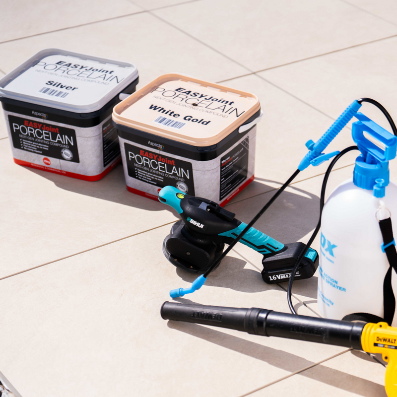 Image of both colours of Azpects EasyJoint Porcelain Next-Gen Jointing Paving Compound which are White gold and Silver, it also has some helpful tools next to it that would help including a compactor and a water sprayer.