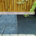 An image of a patio with Azpects Slate & Limestone Enhancer and sealer having been used on half of it to show the difference. The right hand side that it has been used on looks less faded and darker / fresher.