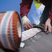 An image of an Easy Trim Easy Ridge Roll kit in Terracotta being fixed to the ridge of a roof