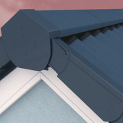 An image of a Grey Easy-Trim Ridge angled end cap  fitted to the the ridge of a roof.