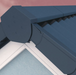 An image of a Grey Easy-Trim Ridge angled end cap  fitted to the the ridge of a roof.