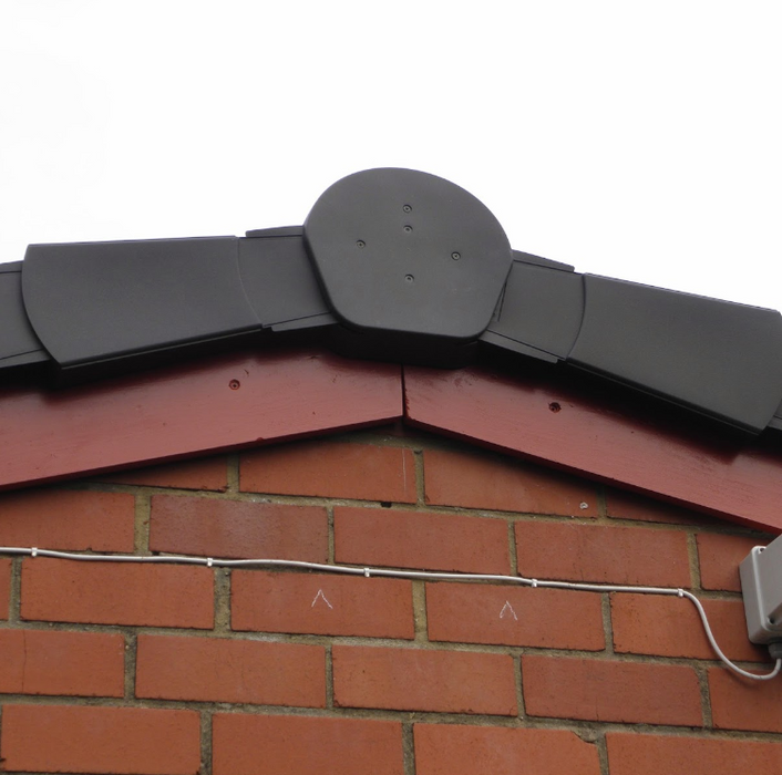 An image of a Grey Easy-Trim Ridge half round end cap  fitted to the the ridge of a roof.