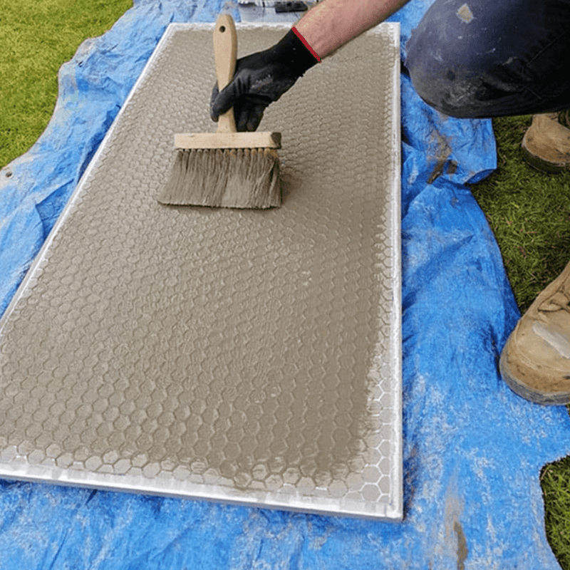 An image of EASYPrime Priming Slurry being applied to the back of a paving slab