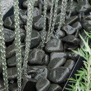 An image showing Ebony Cobble Stone Aggregate Gravel. They are laid as decoration in a water feature.