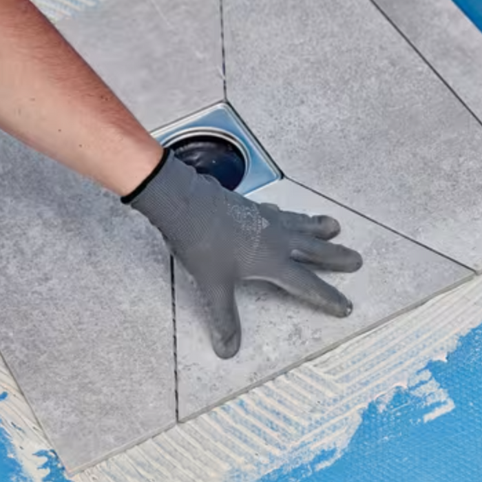 An Image showing tiles being grouted on top of the primer and membrane.