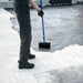 An image of Black Jack 901 Bitumen Paint being painted onto a roof with a long handled roller. It is black in colour.