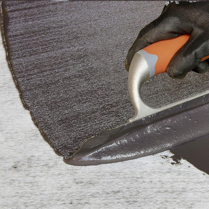 An image of Black Jack DPM 908 being applied to a surface with a trowel.