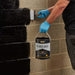 An image of Black Jack DPM 908 being applied to a brick wall with a brush.