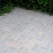 Paved area with stone blocks arranged in a herringbone pattern with Sika Setting Sand used to fill the gaps