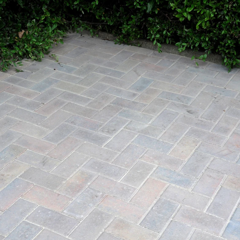 Paved area with stone blocks arranged in a herringbone pattern with Sika Setting Sand used to fill the gaps