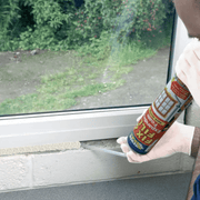 An image of Everbuild fix and fill expanding foam being used to fill a gap in the bottom of a window.