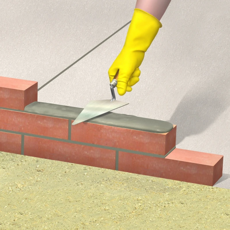 An image of a person using a trowel to apply mortar with Feb Wintamix Frost Proofer 5ltr added to bricks .