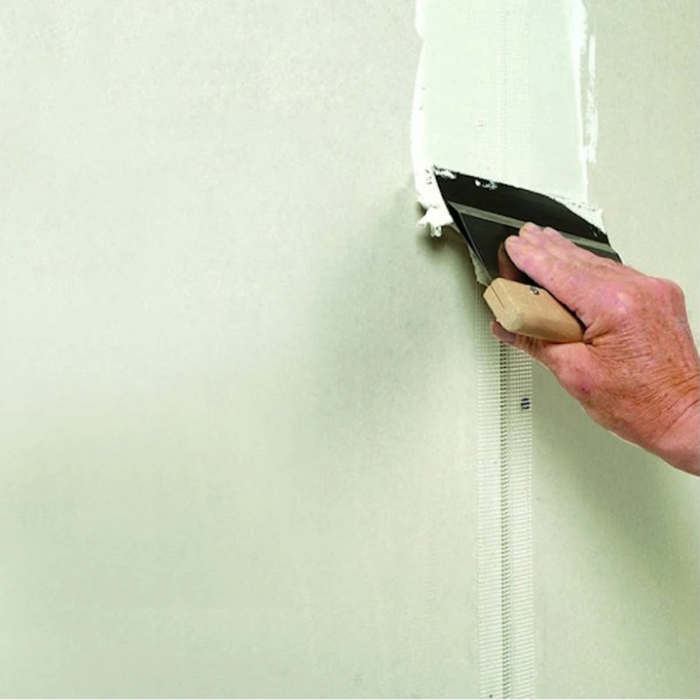 An image of Everbuild Fill and Skim being used to fill a gap between plasterboards using a mesh