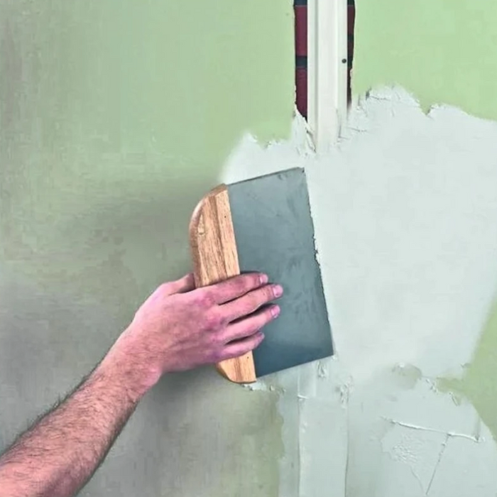 An image of Everbuild Fill and Skim being used to fill an uneven wall.