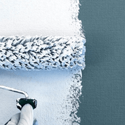 An image of Everbuild Filler Coat being applied to a wall with a roller.