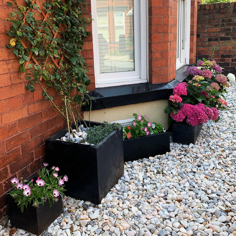 An image of Flamingo Pebble stones laid in a garden in dry conditions to show how they look.