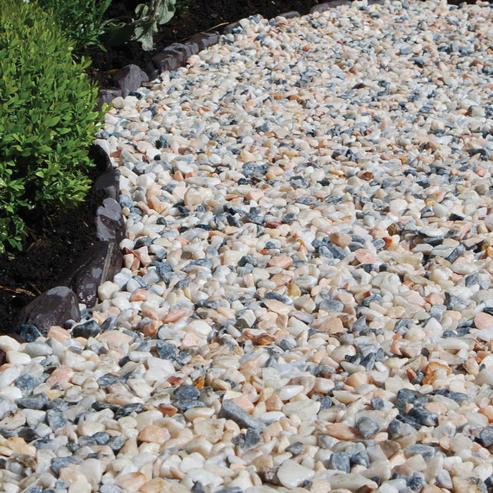 An image of Flamingo Chippings 20mm laid out on a flower bed to show the finish