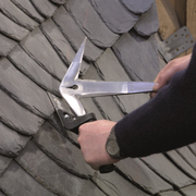 An image of someone on a slate roof using the Freund EDMA Universal Slaters Hammer / Pick.