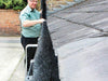 A man installing a gutter brush