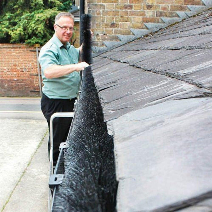 A man installing a gutter brush