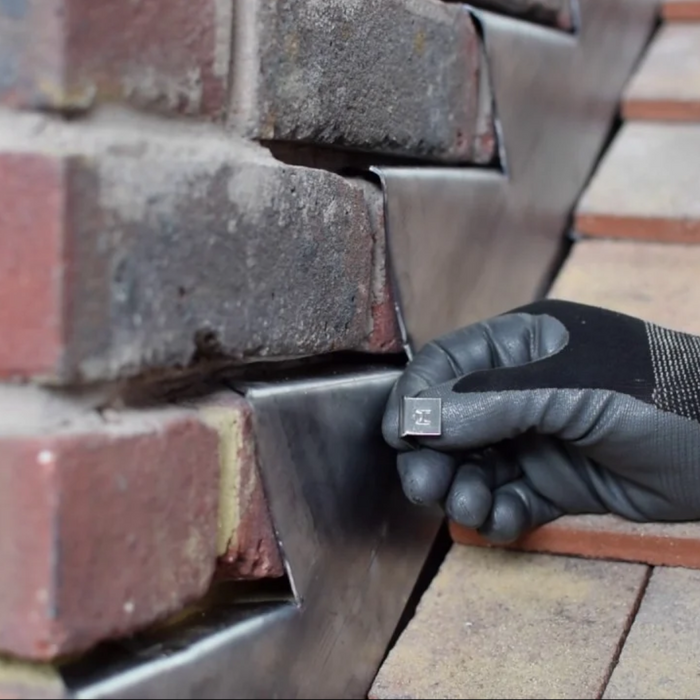 An image of an EasyTrim  Hall Clip / Lead Fixing Clip being used to fix lead flashing to brick.