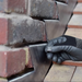 An image of an EasyTrim  Hall Clip / Lead Fixing Clip being used to fix lead flashing to brick.